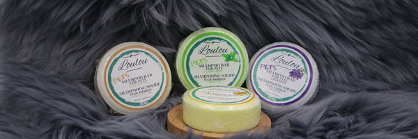 Auf der Abbildung sind feste Hundeshampoos von Loulou in runder Form, in den Duftrichtungen light mint, lavendel, no-scent, citrus